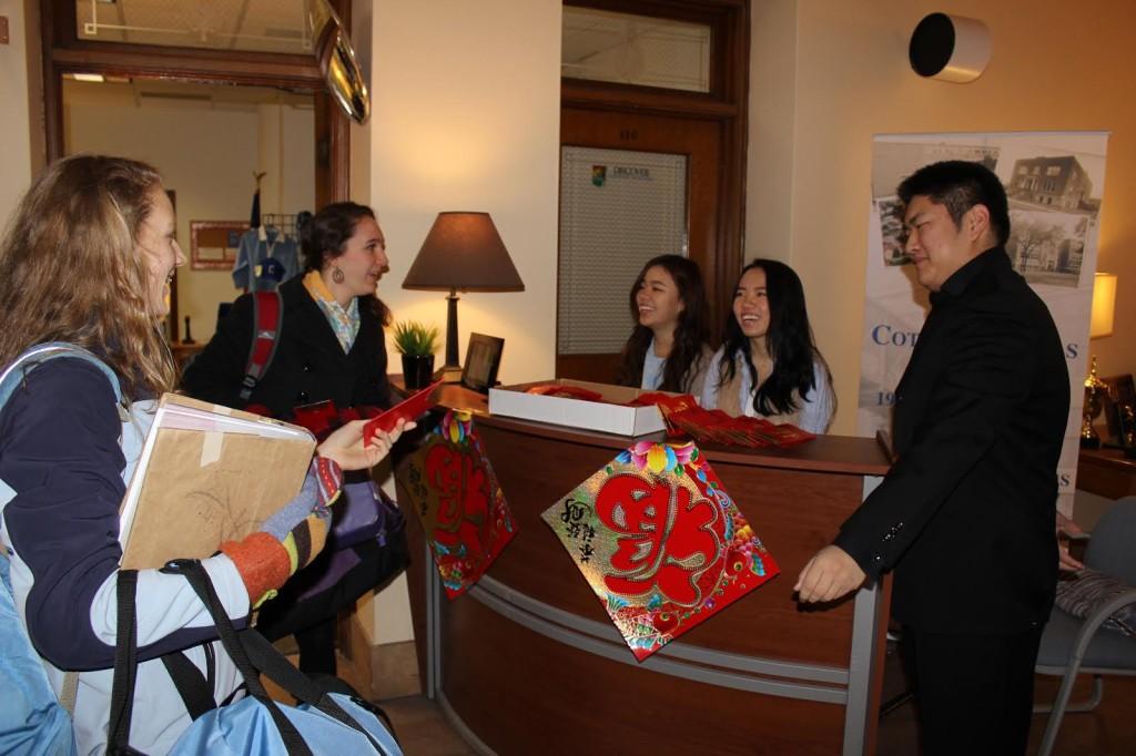 Alice, Jennifer, and Abraham distribute coin envelopes to students