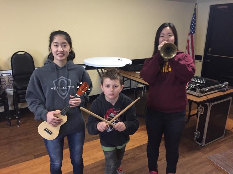 Yuri Ohguru, Colin Ilika, and Sunah Shim test instruments inside the Eagles club at the MWMF petting zoo on April 30.