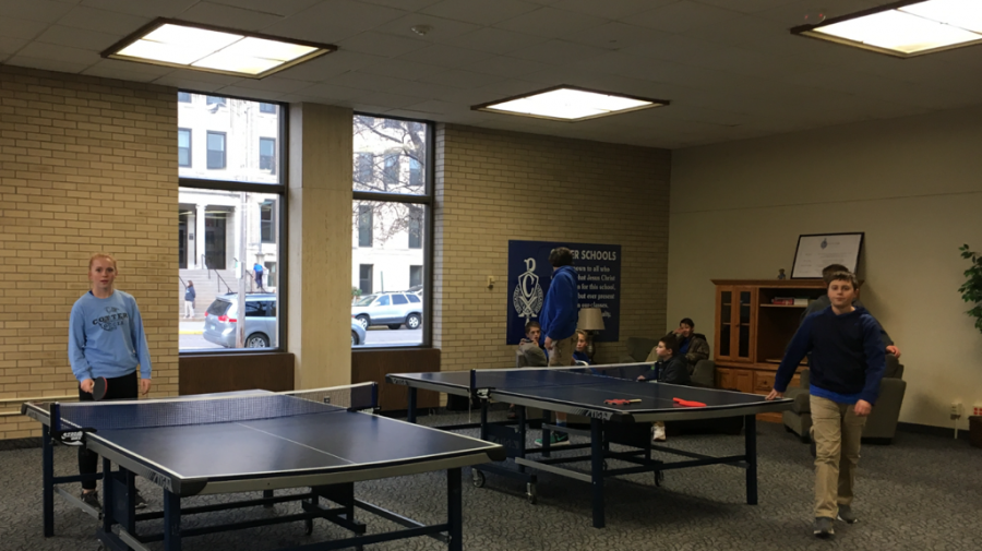Students play ping pong and relax on couches in the student center