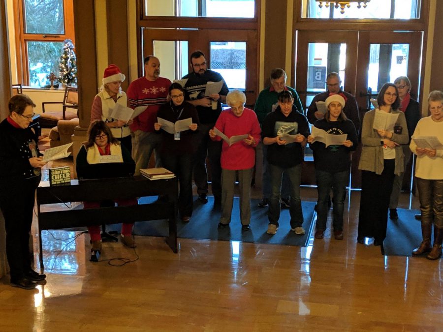 Current and former Cotter faculty and staff sing Christmas carols in the foyer on Monday. 