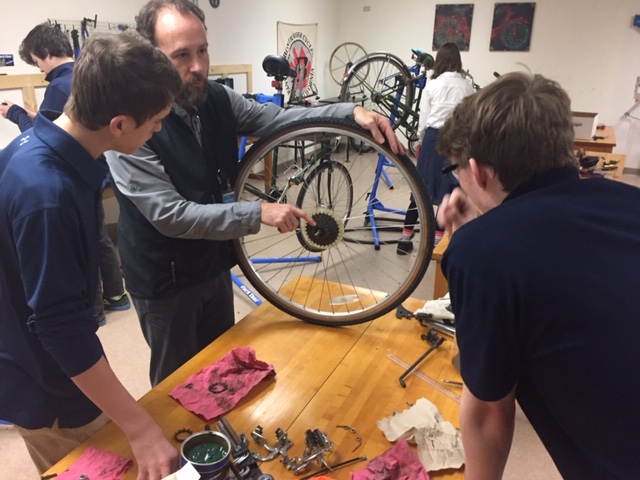 Mr. Paulsen makes a point about the derailleur function to Jordan and Joe in bike lab