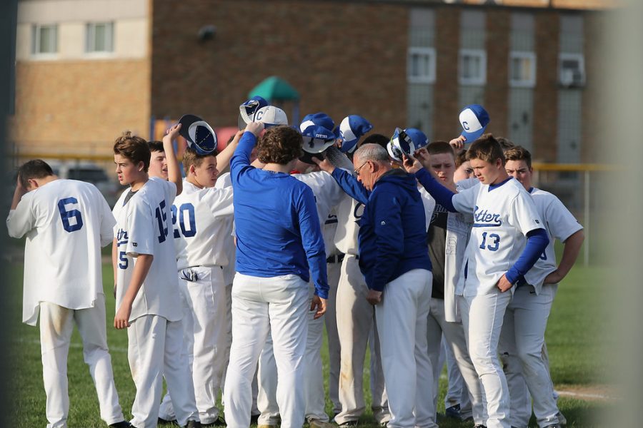 The Cotter baseball teams huddles together at the end of a game.