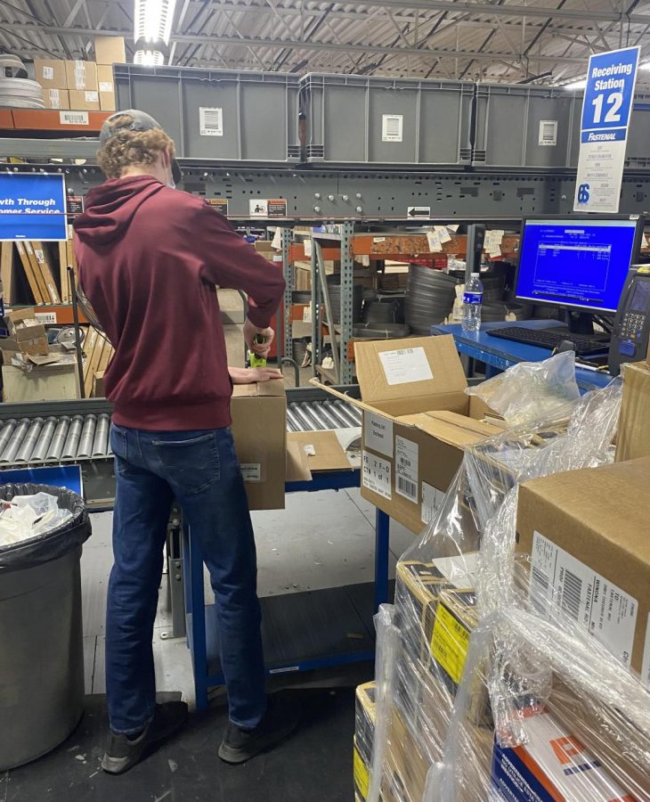 Braden wrapping packages in the receiving department at Fastenal