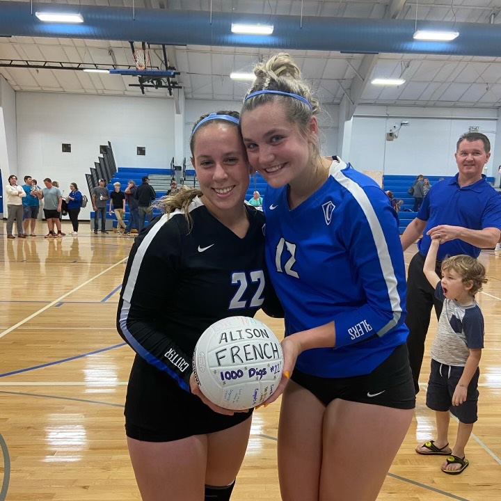 Ali French (L) poses with her 100th dig ball next to fellow senior Olivia Blumers (R)