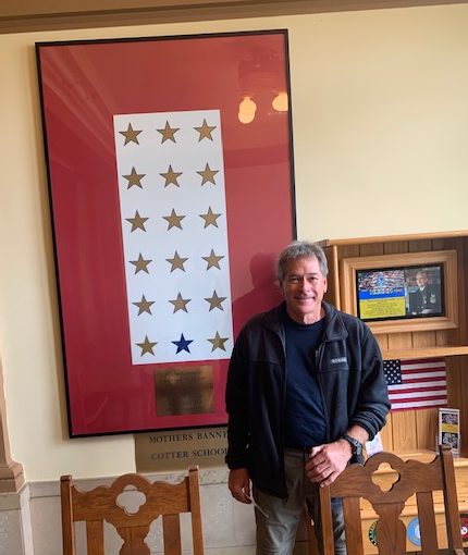Jim Crigler stands in front of the Gold Star families display in St. Teresa Hall at Cotter High School.