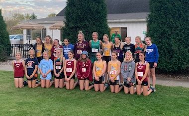 The 21 girls who earned all-conference honors in cross country gather for a photo after the race