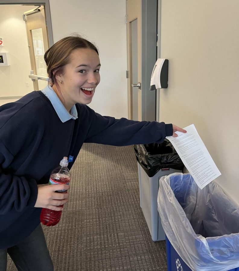 Megan Costello, Cotter senior, happily disposes of paper in the appropriate fashion.