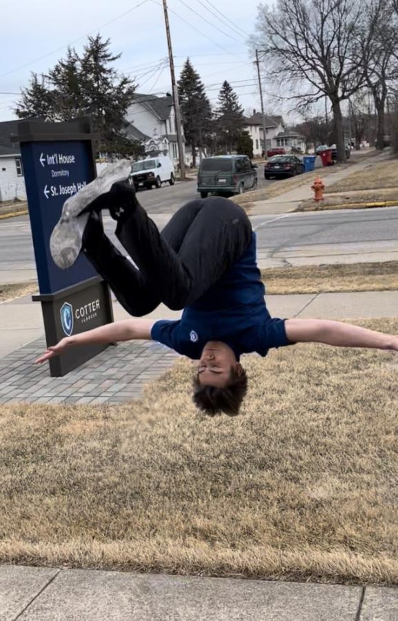 Aero Paulsen executes a running front flip in front of the St. Joseph building