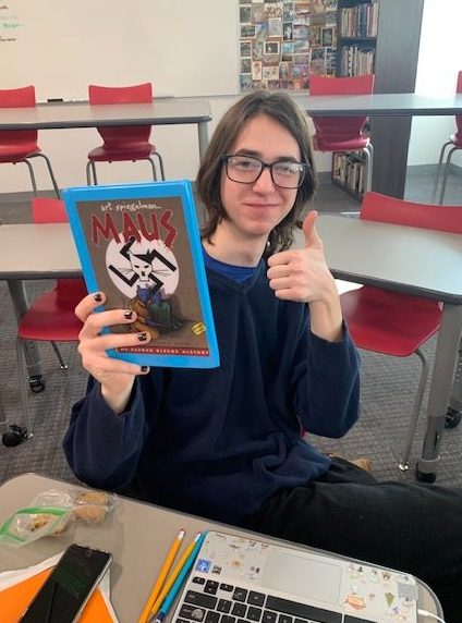 The reporter holding a copy of one of the most widely taught, and recently banned, comics in American schools, Art Spiegelman's Maus