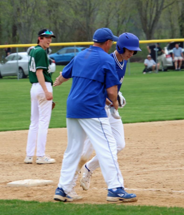 Luke Schommer receives a handshake from Coach Biesanz after hitting his first varsity home run.