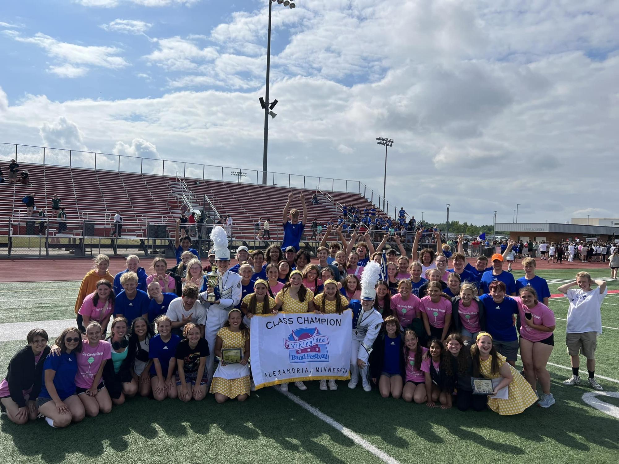 2023 Class A winners, The Cotter Marching Band poses with their victory banner