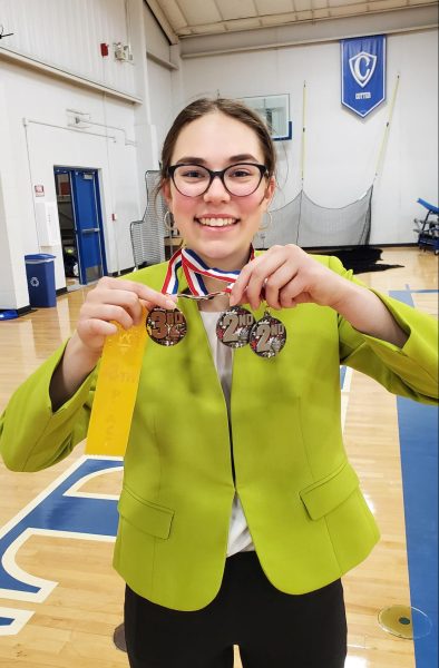 Erica Beckman displays medals she earned by reaching the finals in four categories at the same speech meet