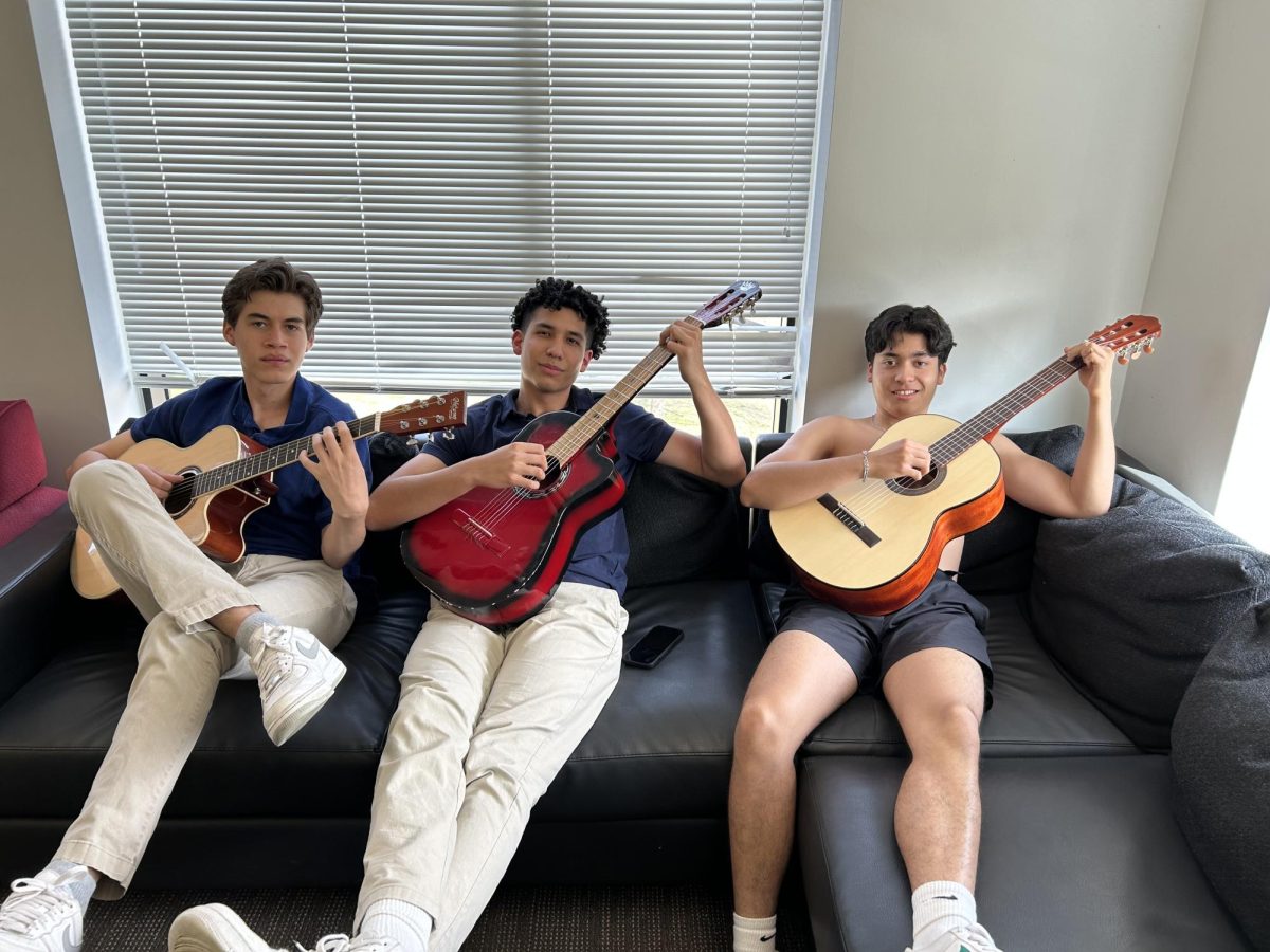 Diego, Mateo, and Rodrigo pose in the dorm lounge with their guitars