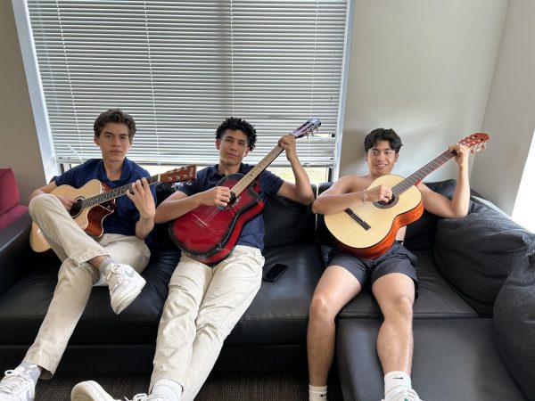 Diego, Mateo, and Rodrigo pose in the dorm lounge with their guitars